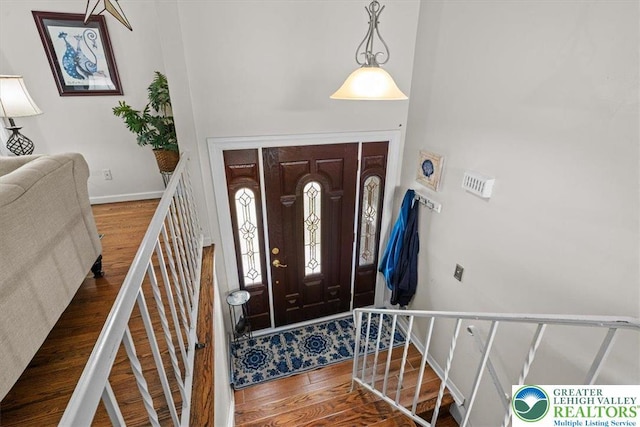 foyer entrance featuring stairway, wood finished floors, and baseboards