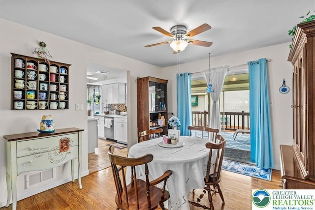 dining room featuring light wood finished floors, ceiling fan, and visible vents
