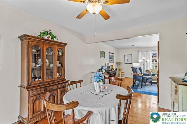 dining room featuring baseboards, light wood-type flooring, and ceiling fan