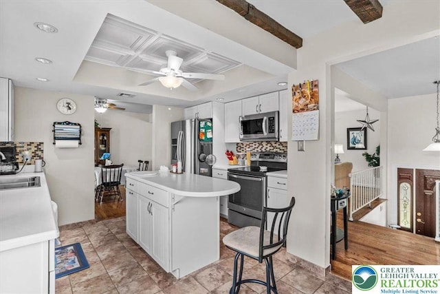 kitchen with a ceiling fan, white cabinets, stainless steel appliances, and tasteful backsplash
