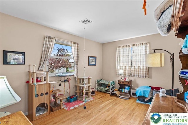 recreation room featuring wood finished floors and visible vents