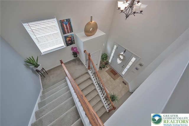 stairs with carpet flooring and an inviting chandelier