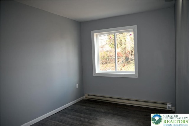 empty room featuring a baseboard radiator, dark wood finished floors, and baseboards