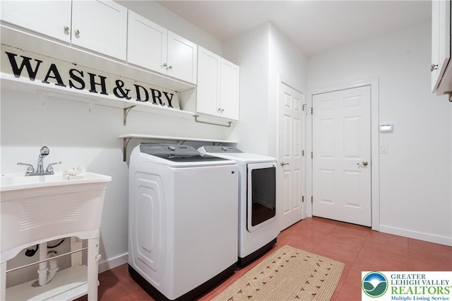 laundry room featuring baseboards, light tile patterned flooring, cabinet space, and washer and clothes dryer