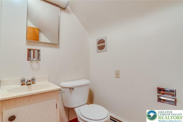 bathroom with vanity, toilet, baseboards, lofted ceiling, and a baseboard radiator