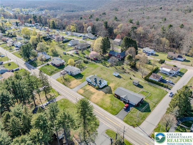 aerial view featuring a forest view and a residential view