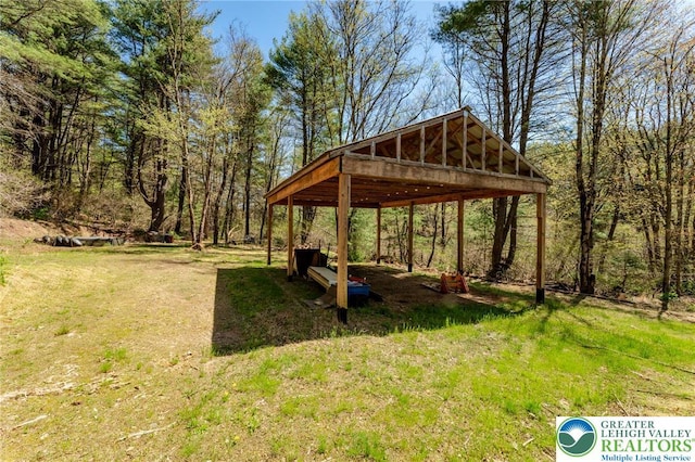 view of property's community featuring a detached carport and a yard