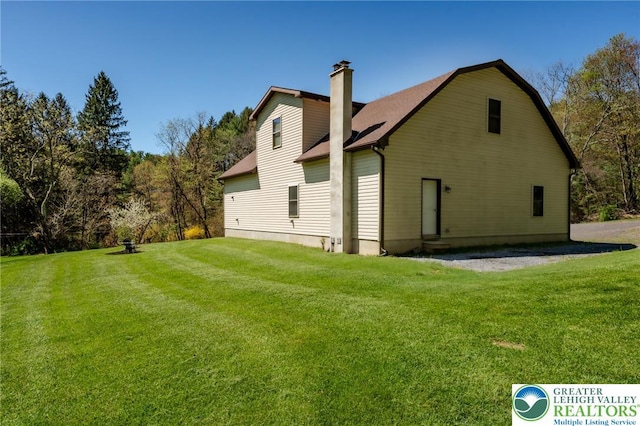 back of property featuring a yard and a chimney
