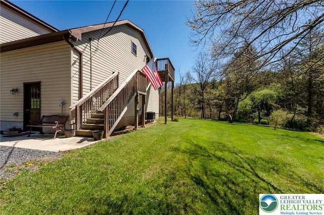 exterior space with a deck, stairway, central AC unit, a lawn, and a patio