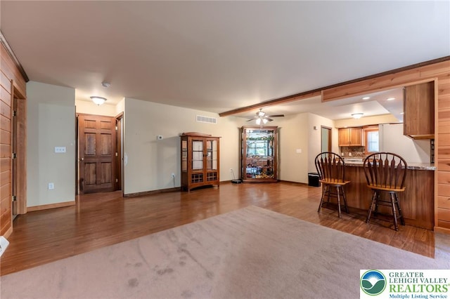 living room featuring baseboards, visible vents, a healthy amount of sunlight, and wood finished floors