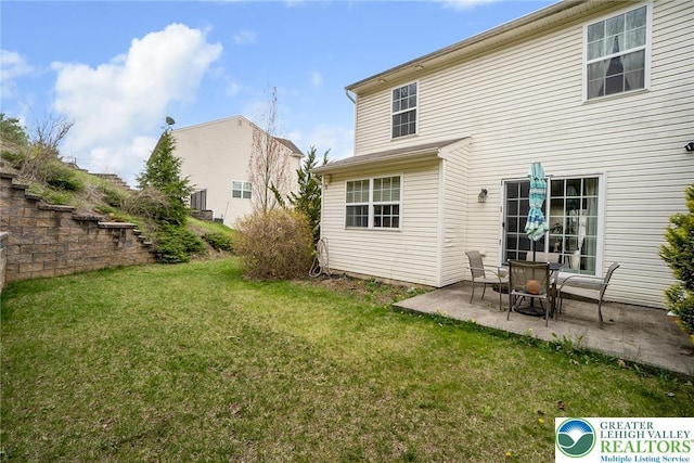 back of house with a patio area and a yard