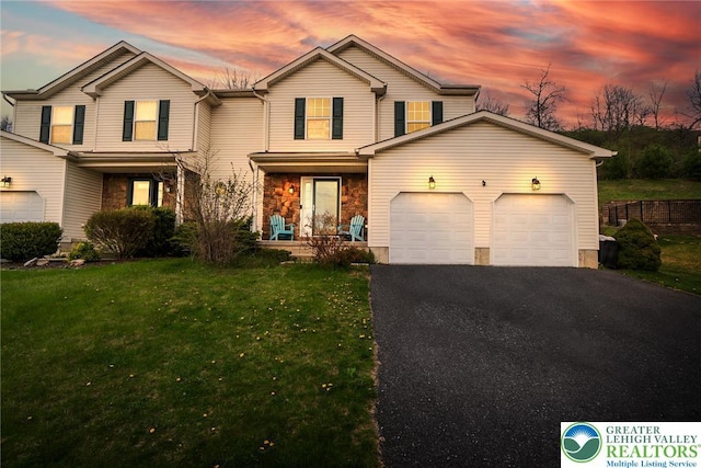 traditional-style home featuring a front lawn, aphalt driveway, stone siding, an attached garage, and a porch