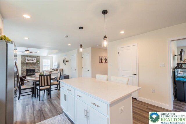 131 Chinaberry Way, Polk Twp, PA 18058 - kitchen with ceiling fan, a stone fireplace, white cabinets, freestanding refrigerator, and dark wood-type flooring