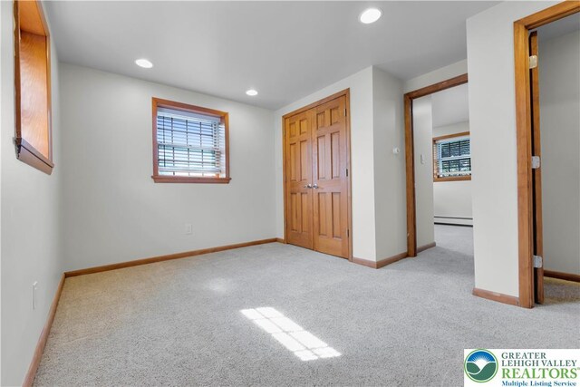 unfurnished bedroom featuring baseboards, a baseboard radiator, carpet, and recessed lighting