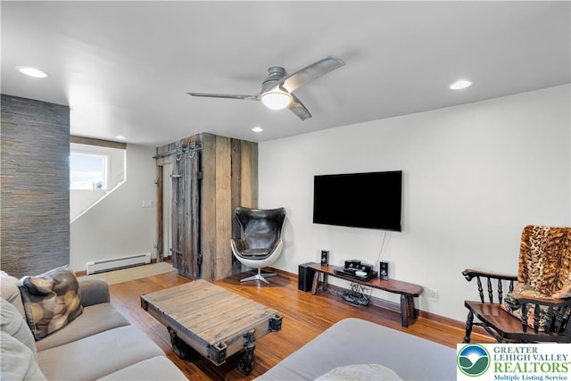 living room with ceiling fan, recessed lighting, baseboards, wood finished floors, and a baseboard heating unit