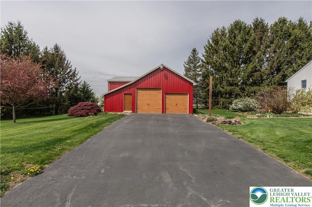 view of side of property featuring a lawn, a detached garage, and an outdoor structure