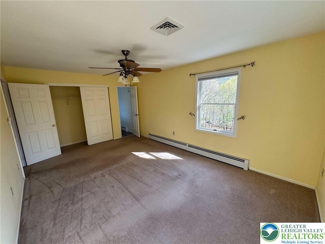 unfurnished bedroom featuring visible vents, baseboards, a baseboard radiator, a closet, and carpet
