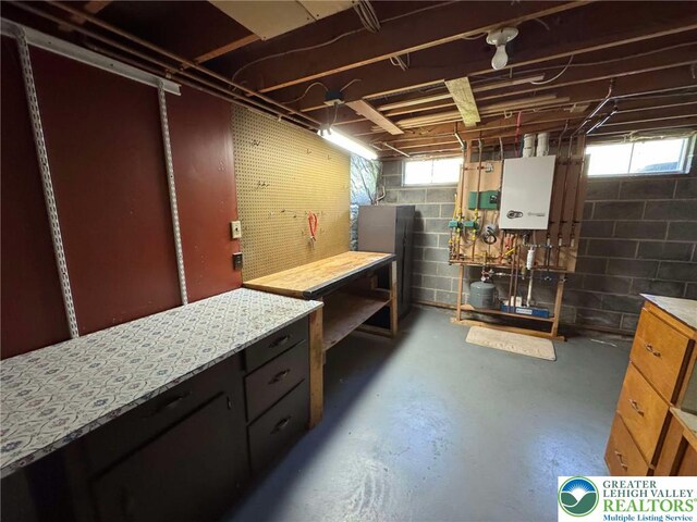 basement with water heater and a workshop area