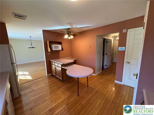 91 Alpine Dr, Jim Thorpe Boro, PA 18229 - kitchen with white appliances, a ceiling fan, light wood-style floors, light countertops, and a chandelier
