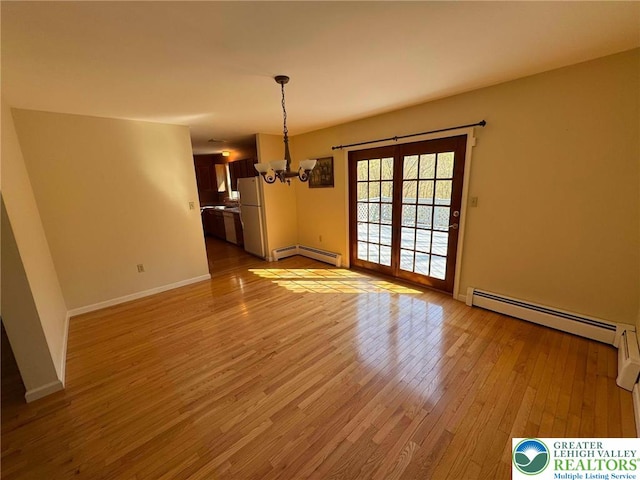 unfurnished dining area with baseboard heating, baseboards, a baseboard radiator, a chandelier, and light wood-style flooring