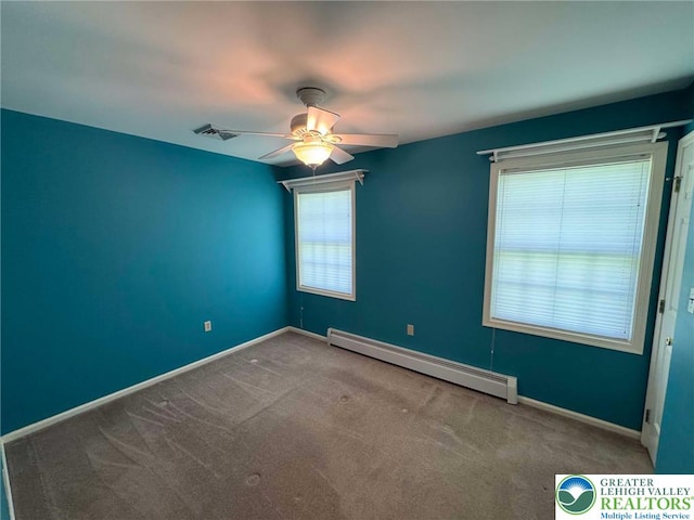 unfurnished room featuring carpet floors, a baseboard radiator, ceiling fan, and visible vents