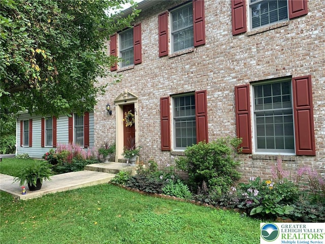 view of front of property with brick siding and a front yard