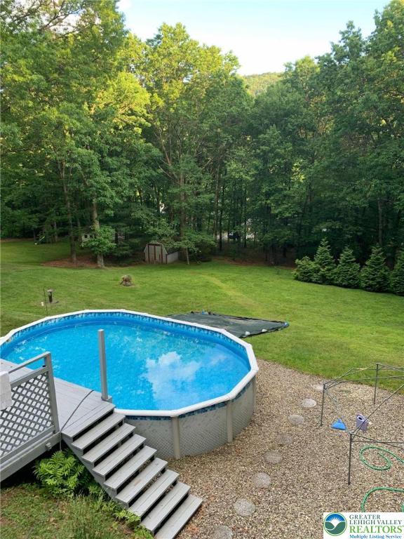 outdoor pool featuring a yard and a forest view