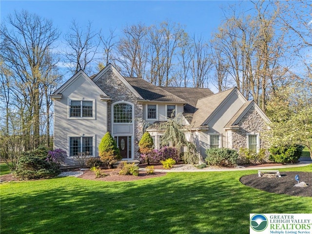 view of front of property with a front yard and stone siding