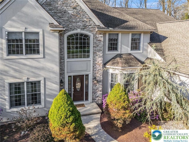 8750 Summit Cir, Weisenberg Twp, PA 18051 - doorway to property featuring stone siding, stucco siding, and a shingled roof
