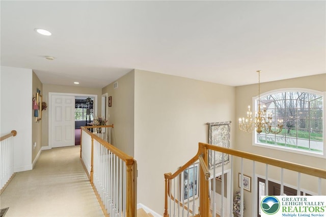 corridor with visible vents, baseboards, recessed lighting, a chandelier, and an upstairs landing