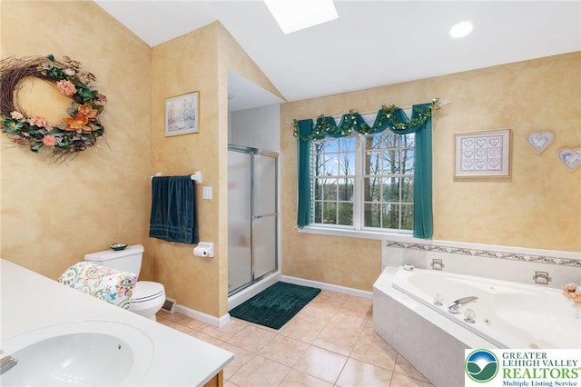 full bathroom featuring a jetted tub, a skylight, a stall shower, vanity, and toilet