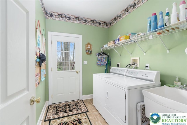 washroom with washer and dryer, laundry area, baseboards, and a sink