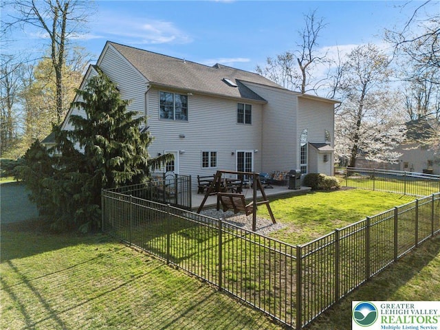 back of house featuring a lawn and a fenced backyard