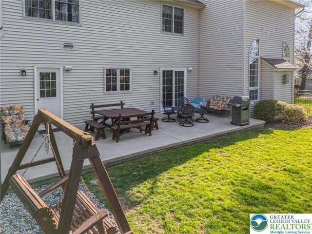 back of property featuring fence, a patio, and a yard