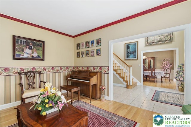 living area with stairway, baseboards, crown molding, and light wood-style floors