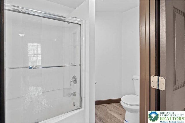 full bath with baseboards, combined bath / shower with glass door, wood finished floors, and toilet