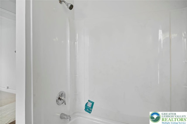 interior details featuring washtub / shower combination