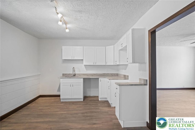 kitchen featuring white cabinets, a textured ceiling, and dark wood-type flooring