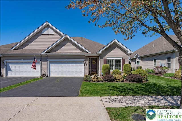 view of front facade featuring an attached garage, a front lawn, and driveway