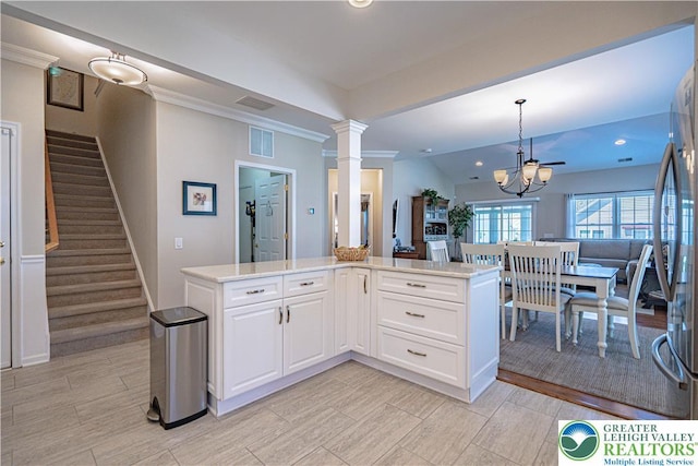 kitchen with visible vents, decorative light fixtures, light countertops, white cabinets, and a notable chandelier