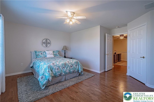 bedroom featuring visible vents, baseboards, and wood finished floors