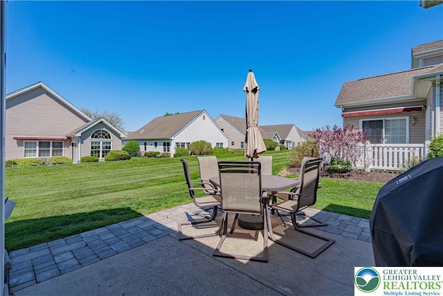 view of patio featuring a residential view, outdoor dining space, and a grill