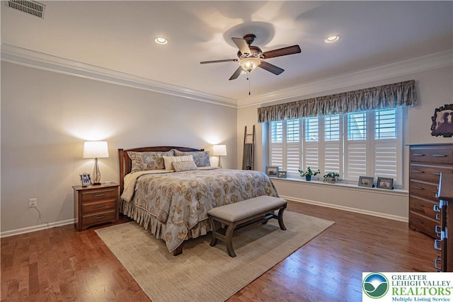 bedroom with baseboards, ornamental molding, wood finished floors, and visible vents