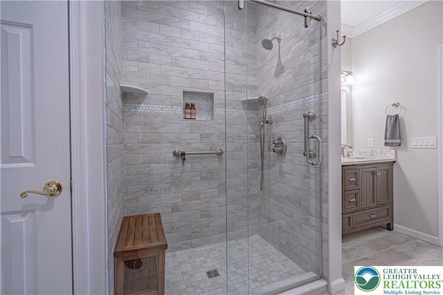 full bath featuring vanity, baseboards, ornamental molding, and a stall shower