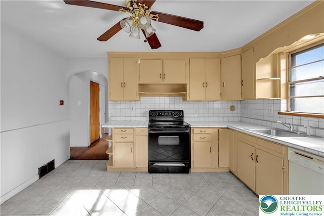 kitchen featuring a sink, cream cabinetry, white dishwasher, and black range with electric stovetop