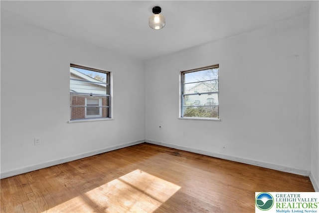 empty room with baseboards and wood finished floors