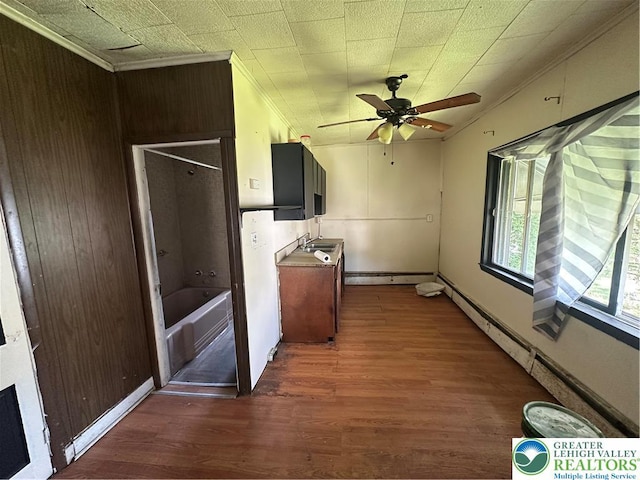 interior space featuring ornamental molding, a ceiling fan, wood finished floors, and baseboard heating