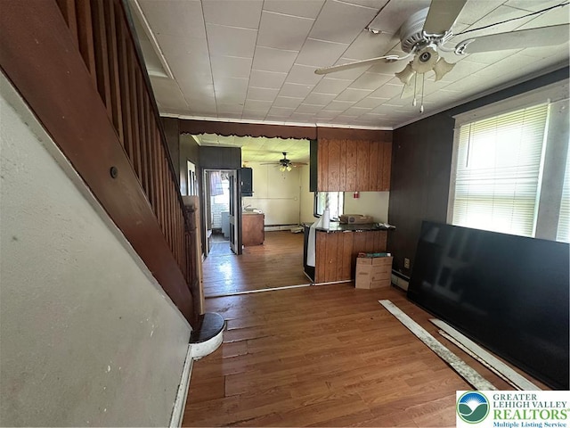 interior space featuring wood finished floors, stairway, and a baseboard radiator