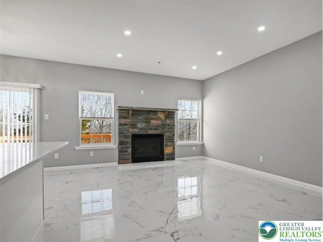 unfurnished living room with baseboards, a fireplace, recessed lighting, and marble finish floor