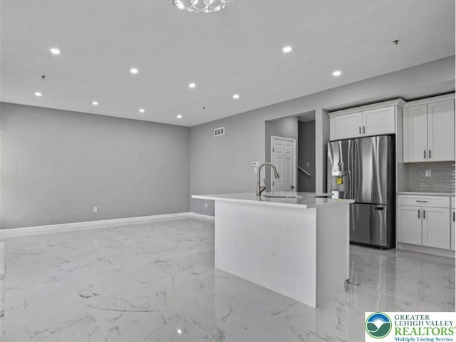 kitchen with stainless steel fridge with ice dispenser, marble finish floor, recessed lighting, white cabinetry, and backsplash
